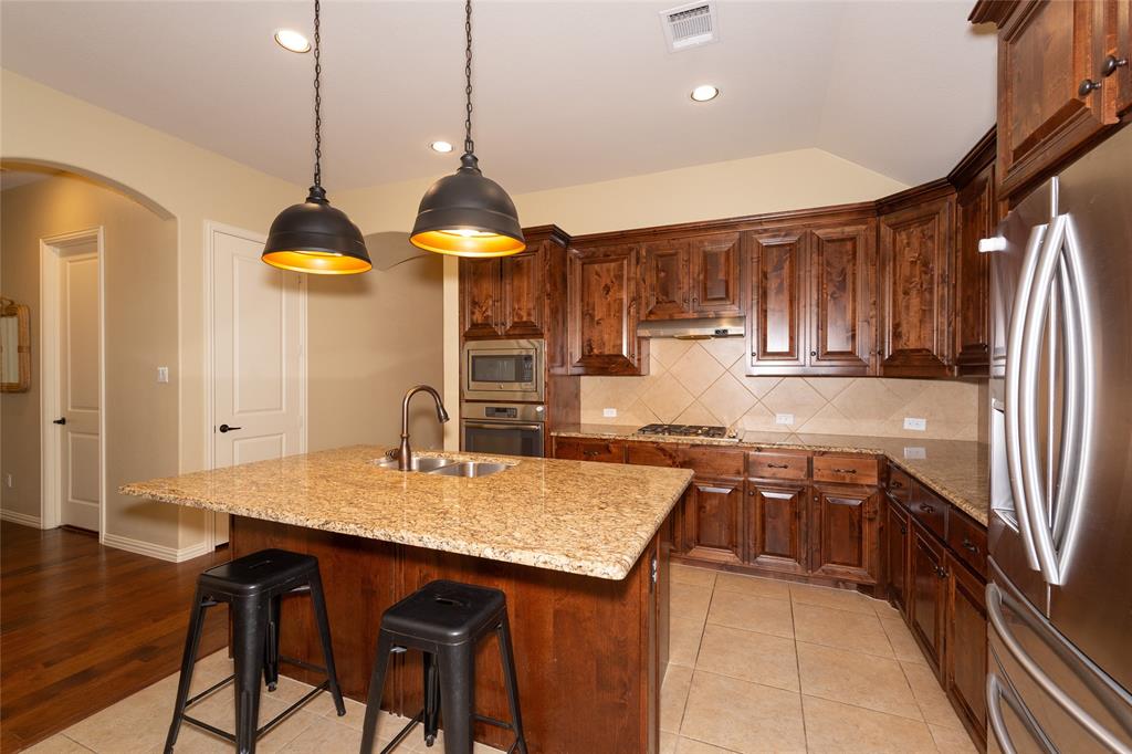 Kitchen featuring rich wood-finish cabinetry, light-toned countertops, and stainless steel appliances