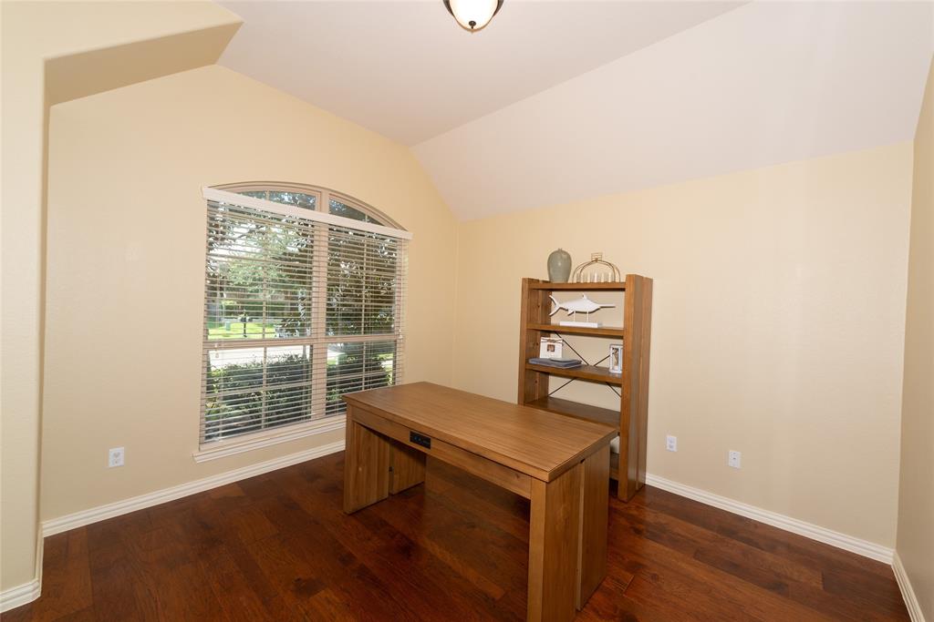 Vaulted ceiling with an arched window and wood-finish flooring Vaulted ceiling with an arched window and wood-finish flooring