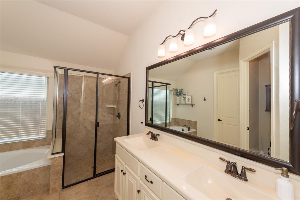 Dual vanity with undermount sinks, bronze fixtures, and a large framed mirror
