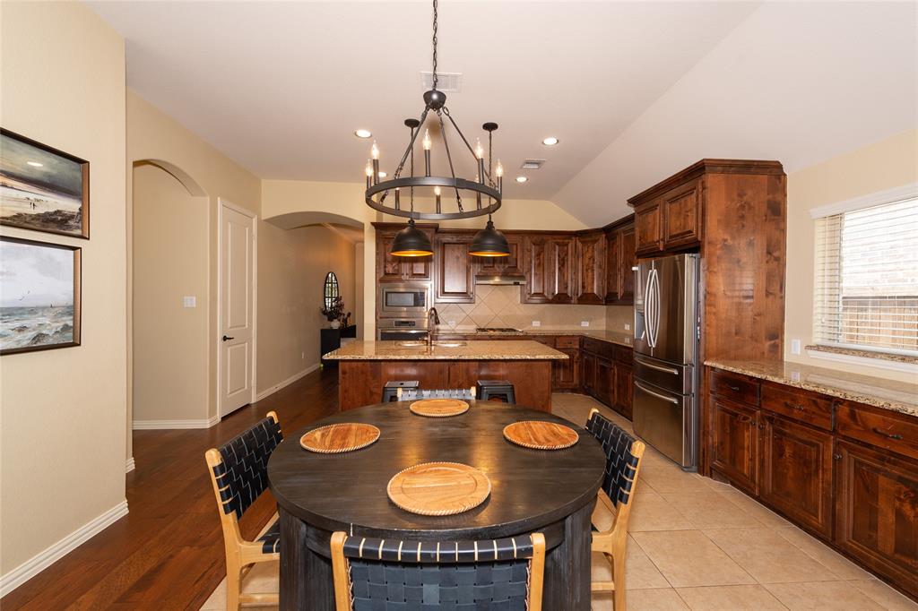 Spacious kitchen featuring rich wood cabinetry, stainless steel appliances, a large center island, and recessed lighting