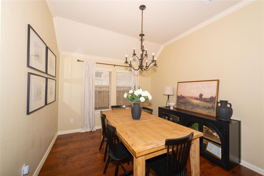 Vaulted ceiling, crown molding, wood-finish flooring, and a multi-pane window with blinds Vaulted ceiling, crown molding, wood-finish flooring, and a multi-pane window with blinds