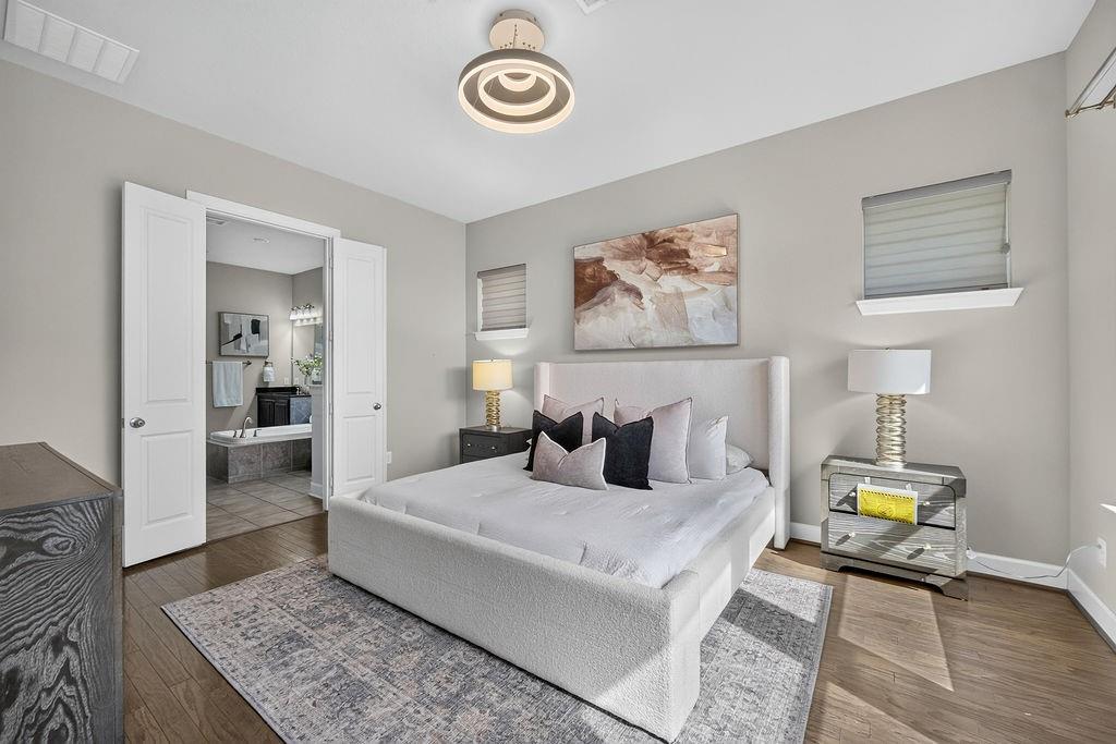 Neutral-toned walls, wood-finish flooring, and a modern circular tiered flush-mount light fixture