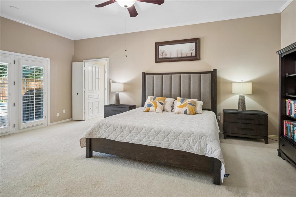 Ceiling fan with light fixture, light-colored carpeting, white paneled double doors, white interior door, and neutral wall paint