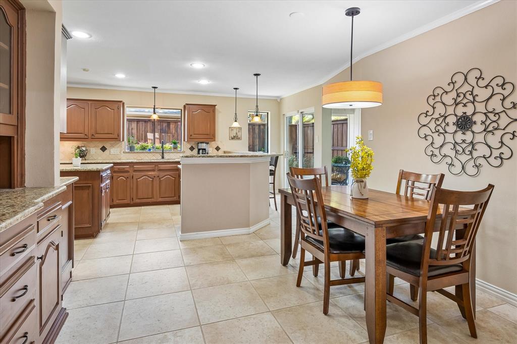 Kitchen and dining area featuring wood cabinetry, stone countertops, tile flooring, and recessed lighting
