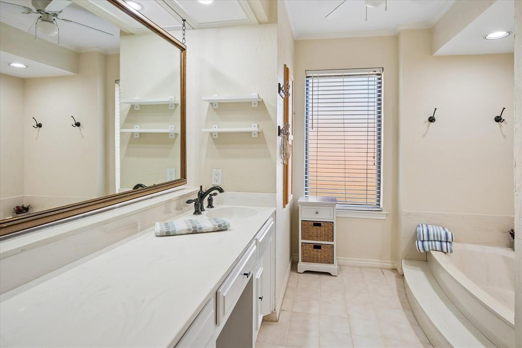 Double vanity with integrated sink, rectangular window, built-in bathtub, and recessed lighting