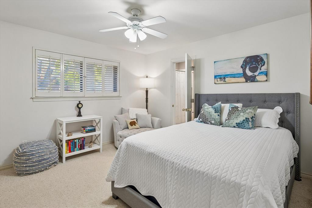 Neutral tone wall finishes, white plantation shutters, and a ceiling fan with integrated lighting