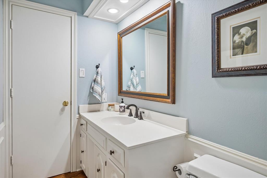 White vanity with under-sink storage, integrated basin, and dark bronze-finish fixtures