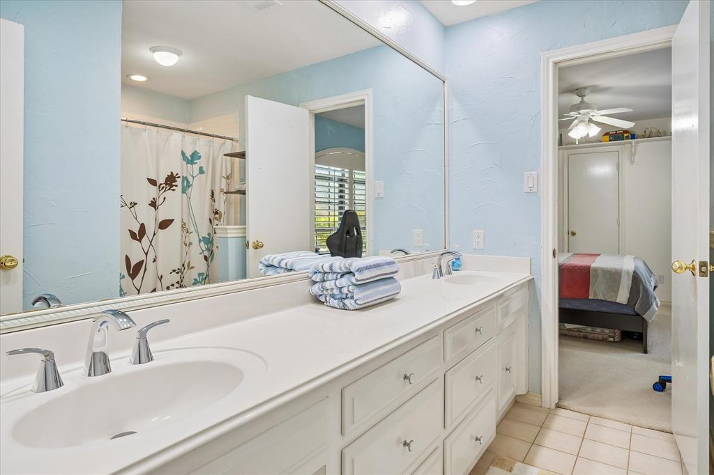 Dual under-mount sinks with chrome faucets, expansive countertop, and built-in vanity cabinetry