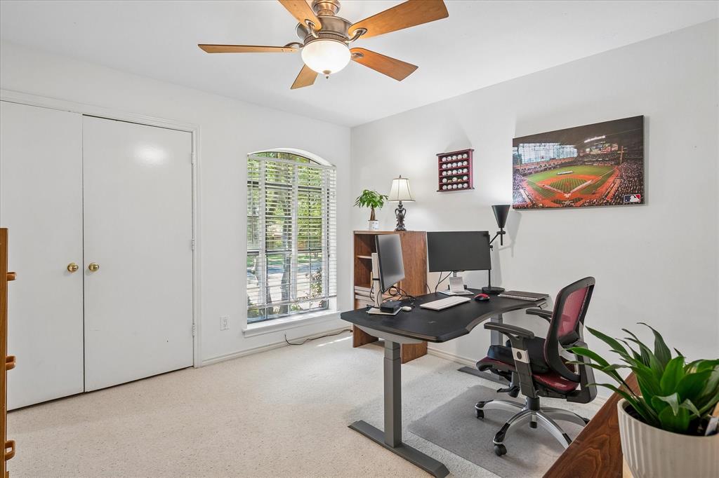 Carpeted room featuring a ceiling fan with integrated lighting, an arched window, and bi-fold closet doors