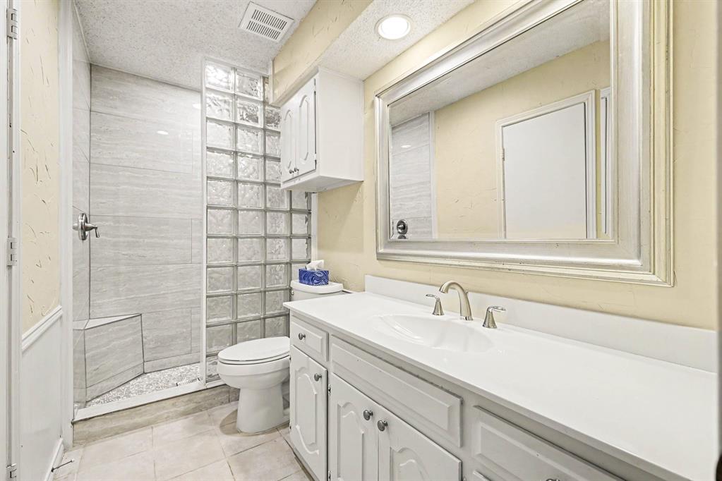 Walk-in shower with tiled walls and a built-in bench