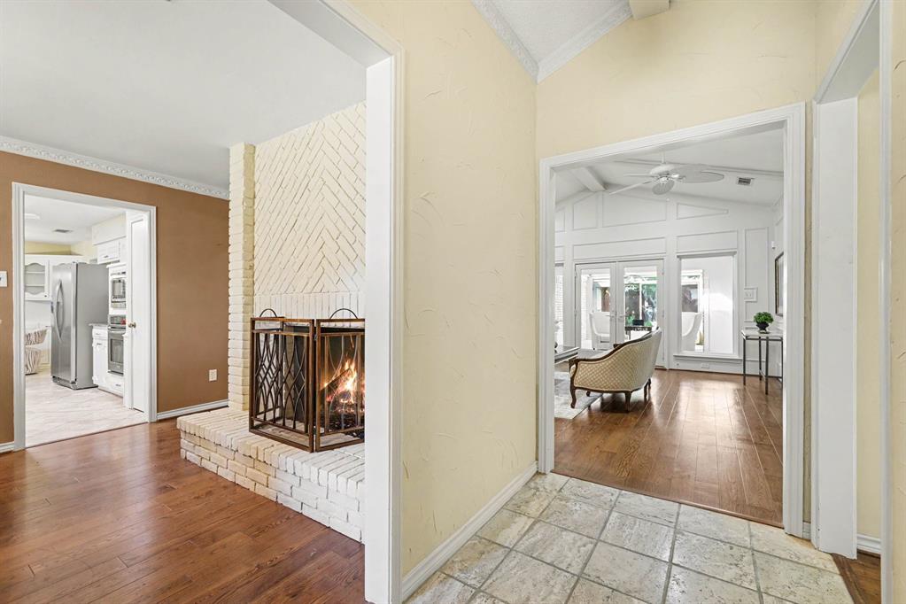 White brick fireplace with an elevated hearth, wood-finish flooring, and vaulted ceilings White brick fireplace with an elevated hearth, wood-finish flooring, and vaulted ceilings