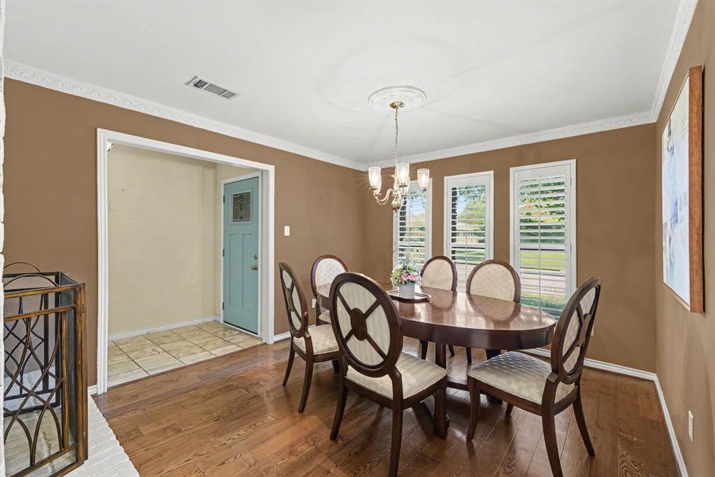Hardwood flooring, crown molding, and a chandelier with a ceiling medallion Hardwood flooring, crown molding, and a chandelier with a ceiling medallion