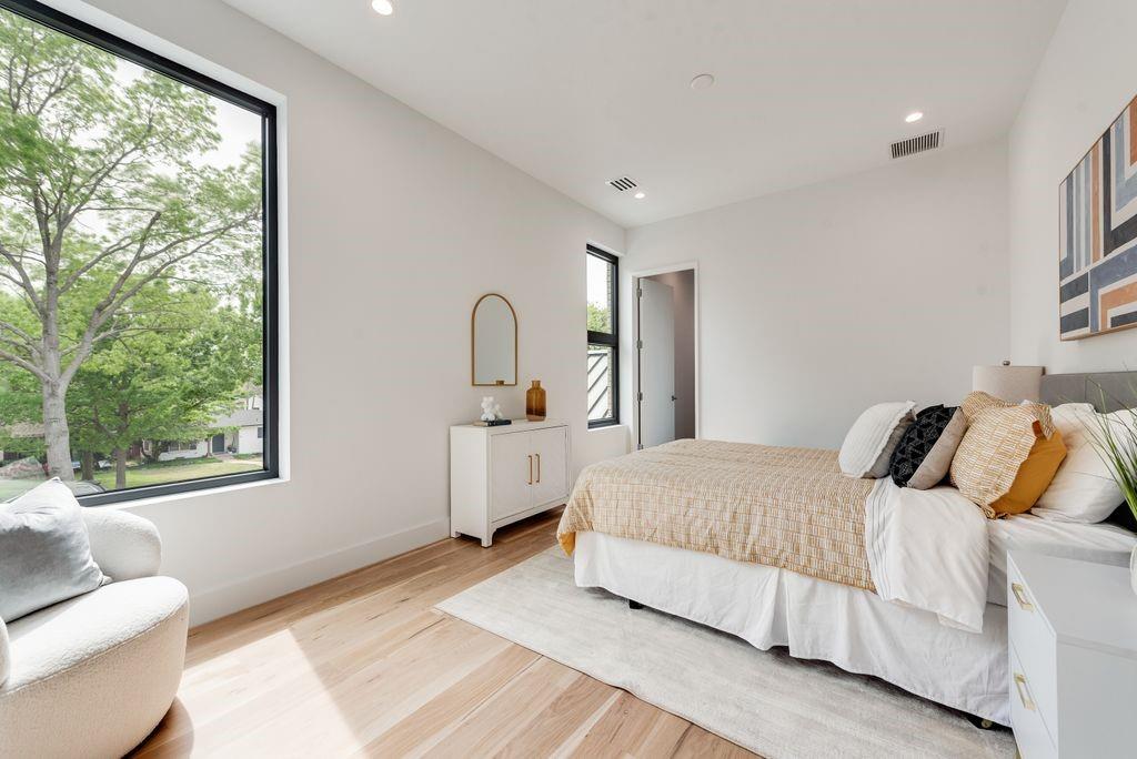 The second floor bedroom/guest suite offers a quiet and comfortable retreat overlooking huge yard and massive trees.