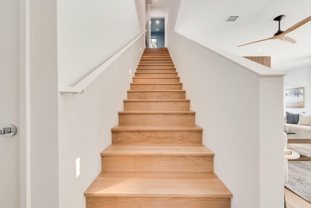 White oak stairs gracefully leading to the second floor, fitness room, second laundry "The treehouse" balcony and guest bedrooms