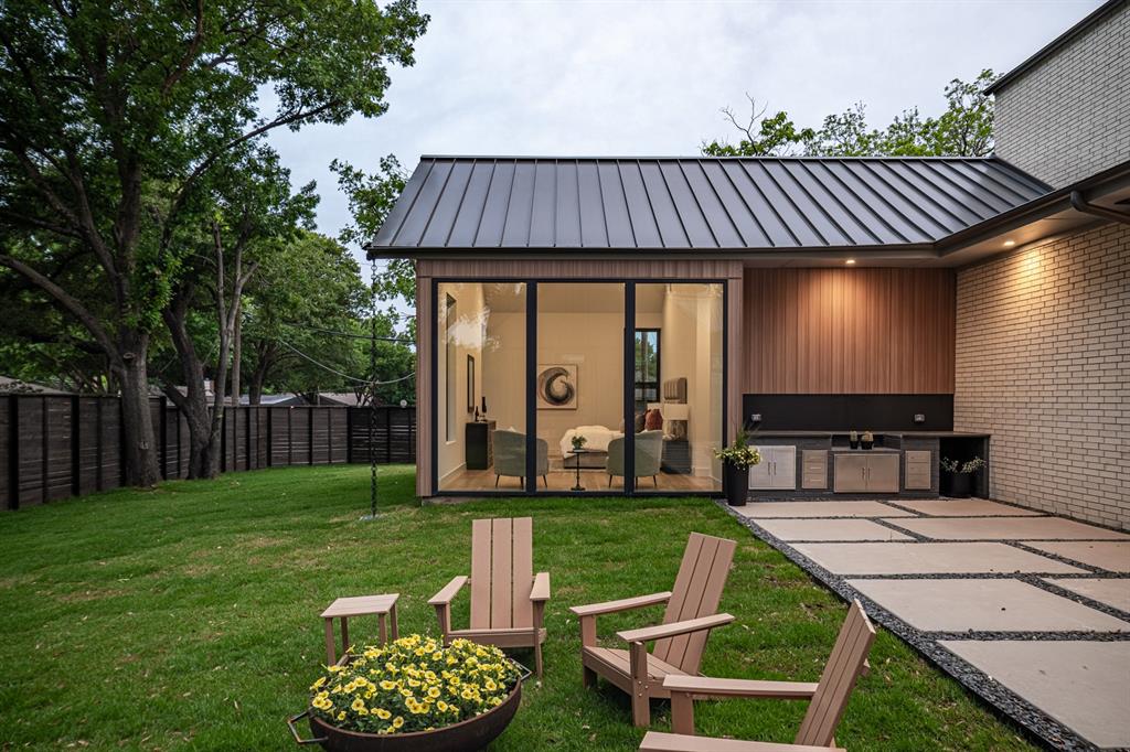 A built-in BBQ makes entertaining effortless while expansive windows overlook the beautifully landscaped backyard, creating a visual connection between the primary suite and outdoor living spaces.