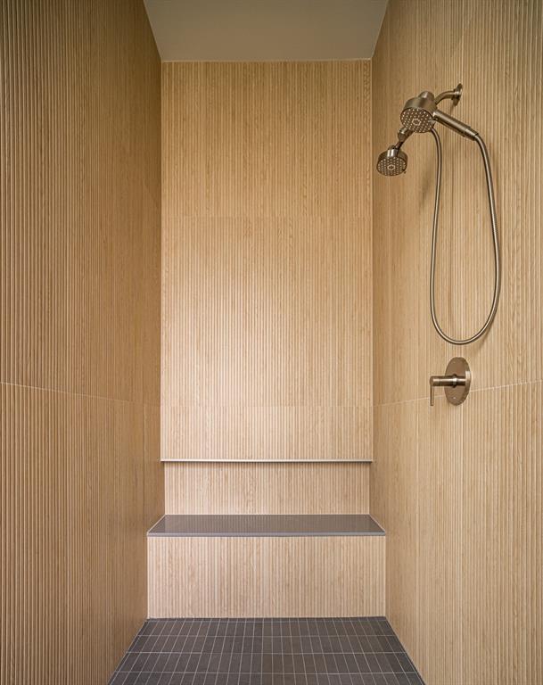 Oversized dual shower with ribbon tile, quartz bench and niche.