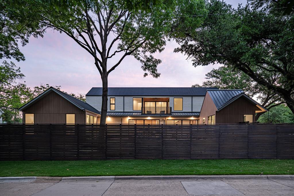 Custom horizontal cedar fence framing majestic trees and magnificent modern home