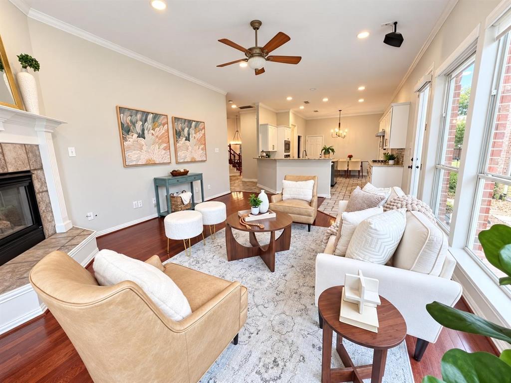 Open-concept living space featuring wood-finish flooring, a ceiling fan, recessed lighting, and large windows