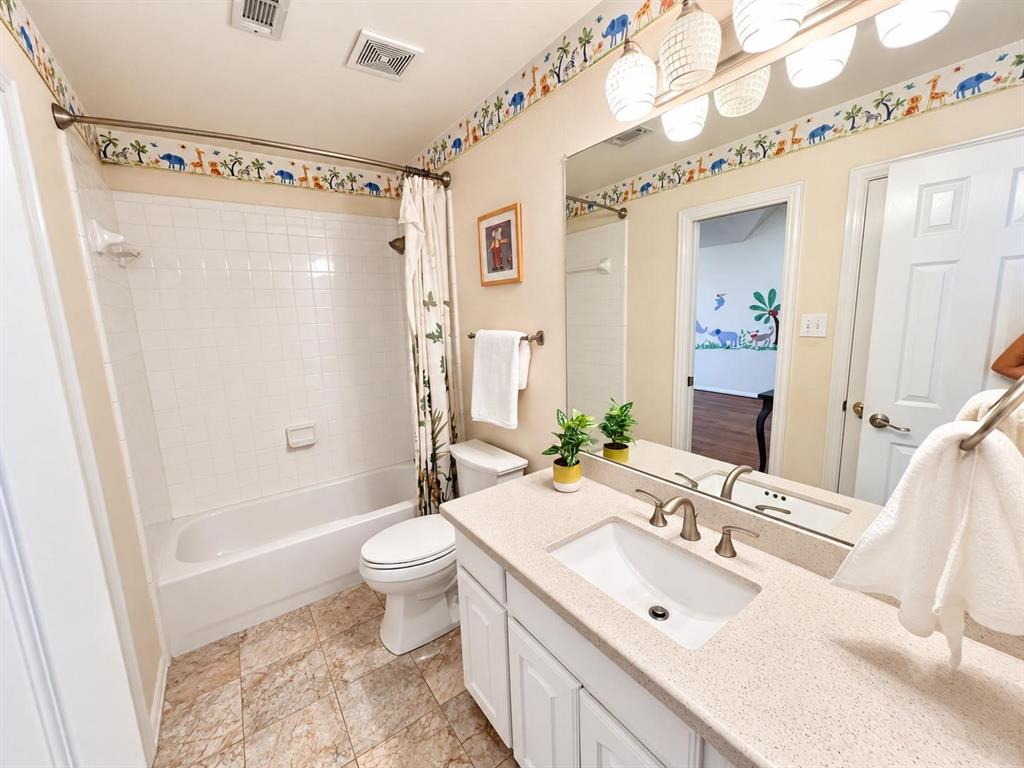 Bathroom featuring a single vanity with an integrated sink, brushed nickel faucet, large wall mirror, and overhead lighting
