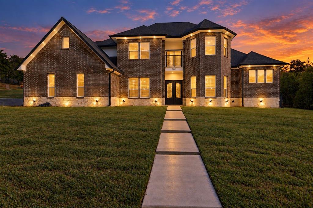 Brick exterior with stone accents, a multi-gabled roofline, and a prominent entry with double doors
