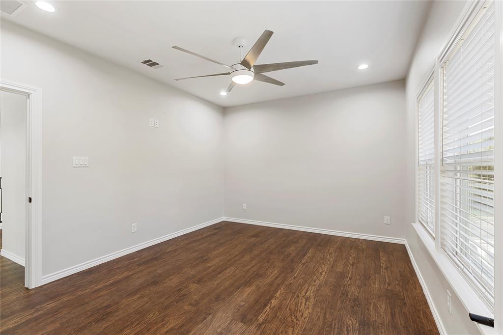 Wood-finish flooring, two large windows with blinds, recessed ceiling lighting, and a modern ceiling fan