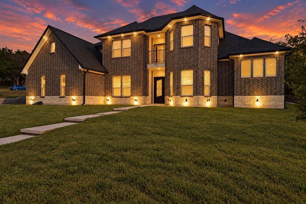 Two-story brick facade with stone accent detailing, multiple windows, and a prominent front entry Two-story brick facade with stone accent detailing, multiple windows, and a prominent front entry