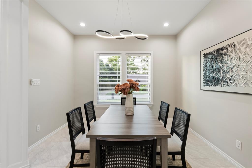 Recessed lighting, contemporary linear chandelier, window with blinds, light-toned walls, and wood-finish flooring Recessed lighting, contemporary linear chandelier, window with blinds, light-toned walls, and wood-finish flooring