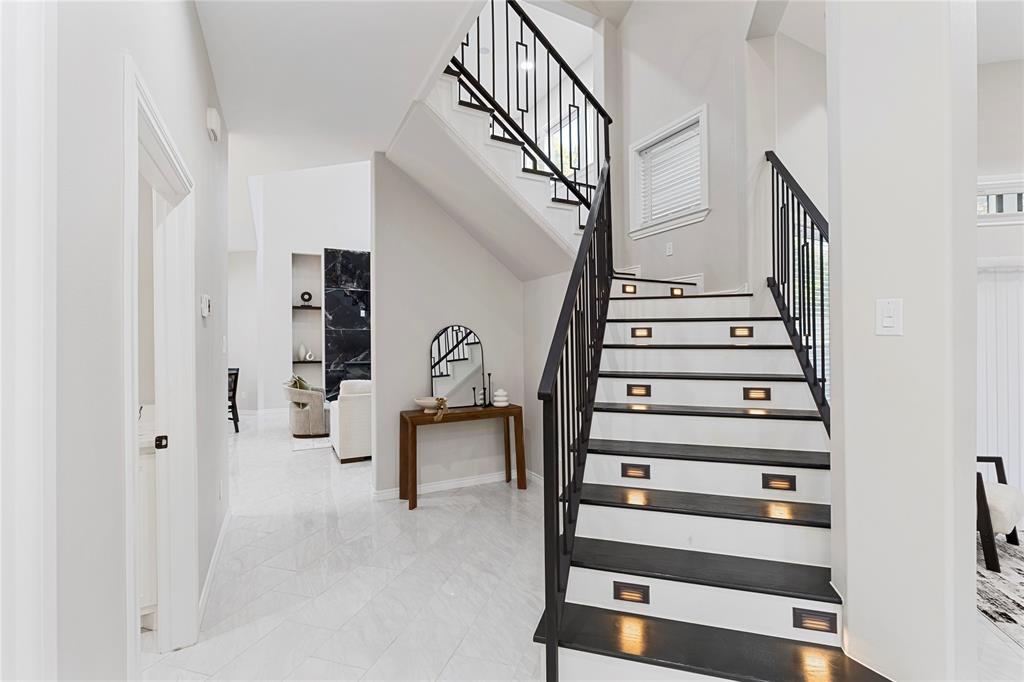 Staircase featuring dark treads, white risers, and contemporary black metal railings Staircase featuring dark treads, white risers, and contemporary black metal railings