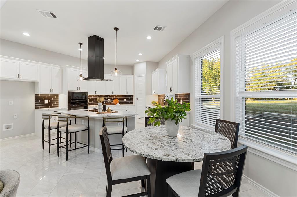 White cabinetry with dark hardware and a brown brick-patterned backsplash