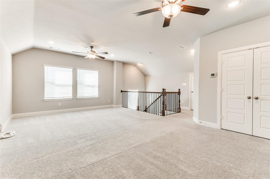 Spacious carpeted area with vaulted ceilings, multiple windows with blinds, and recessed lighting Spacious carpeted area with vaulted ceilings, multiple windows with blinds, and recessed lighting