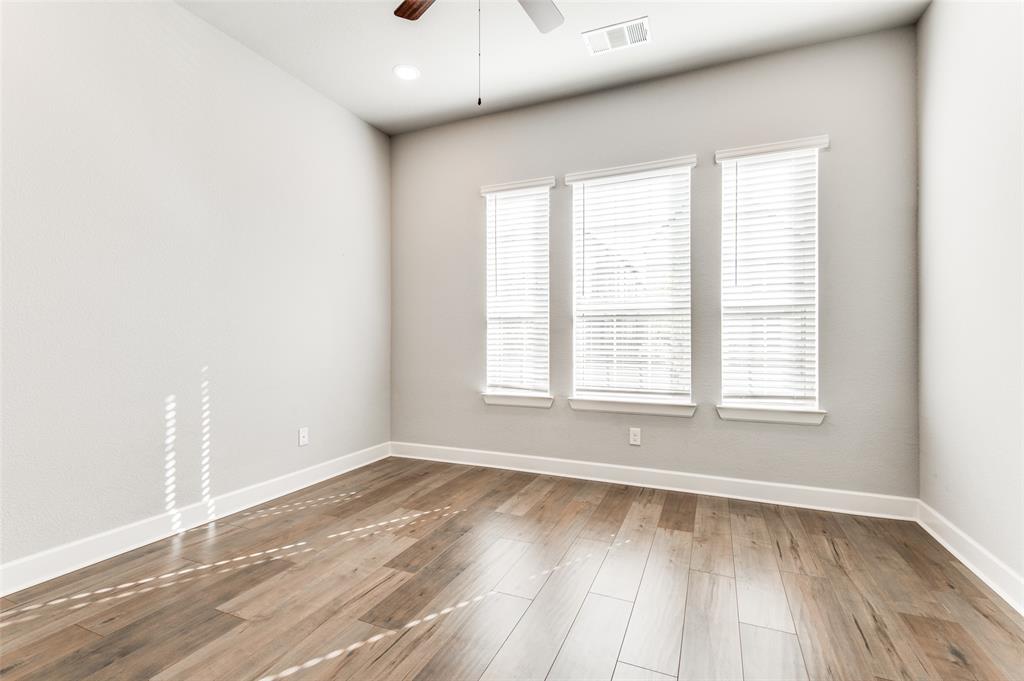 Wood-finish flooring, three windows with blinds, recessed ceiling light, ceiling fan, and white trim Wood-finish flooring, three windows with blinds, recessed ceiling light, ceiling fan, and white trim