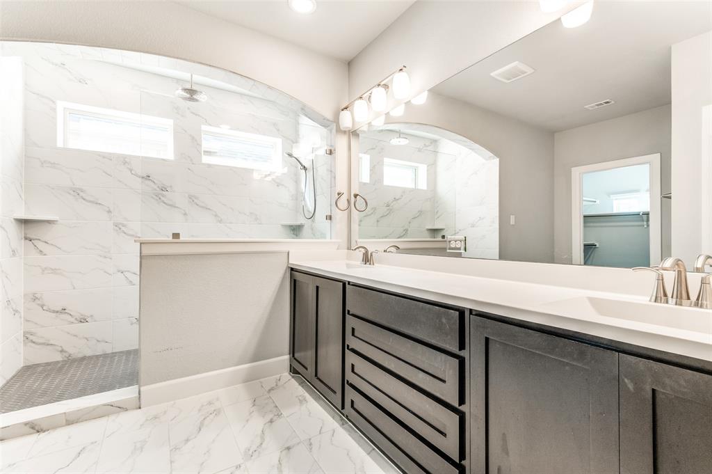 Dual vanity with dark wood-finish cabinetry, white countertop, and brushed nickel fixtures Dual vanity with dark wood-finish cabinetry, white countertop, and brushed nickel fixtures