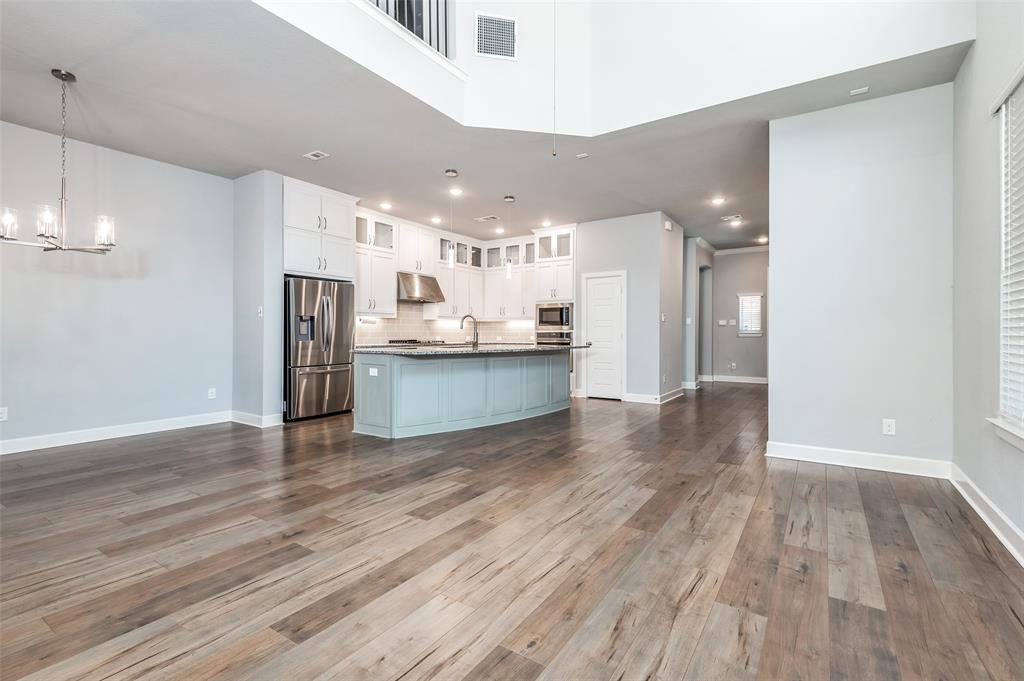 Wood-finish flooring throughout, kitchen with stainless steel appliances, central island with seating, pendant lighting, and recessed lighting Wood-finish flooring throughout, kitchen with stainless steel appliances, central island with seating, pendant lighting, and recessed lighting