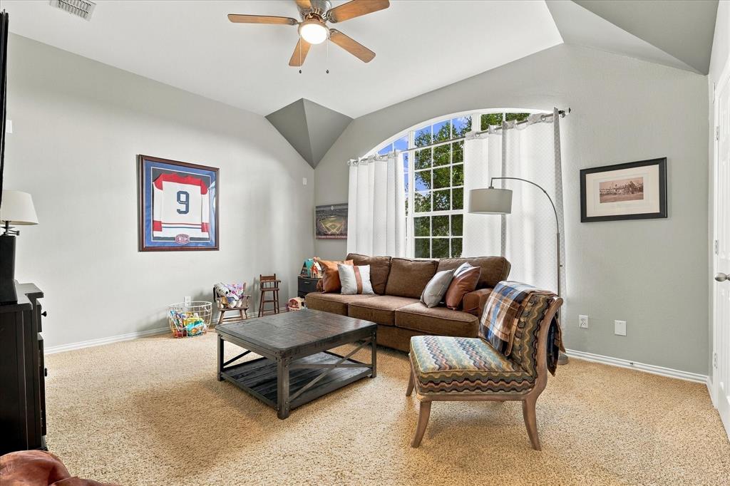 Vaulted ceilings, expansive arched window, and integrated ceiling fan