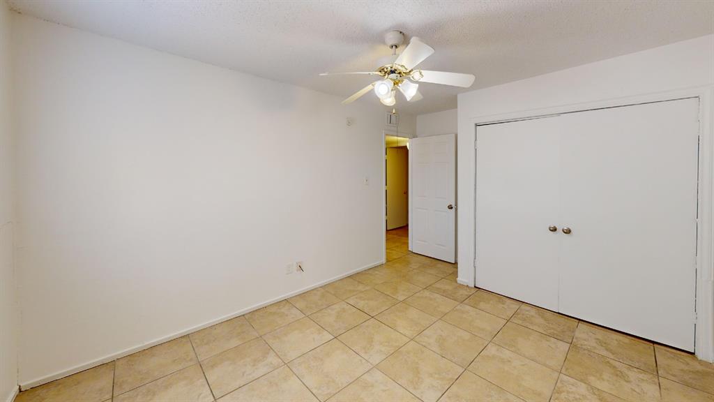 Ceramic tile flooring, bi-fold closet doors, ceiling fan with light fixture, and a paneled interior door