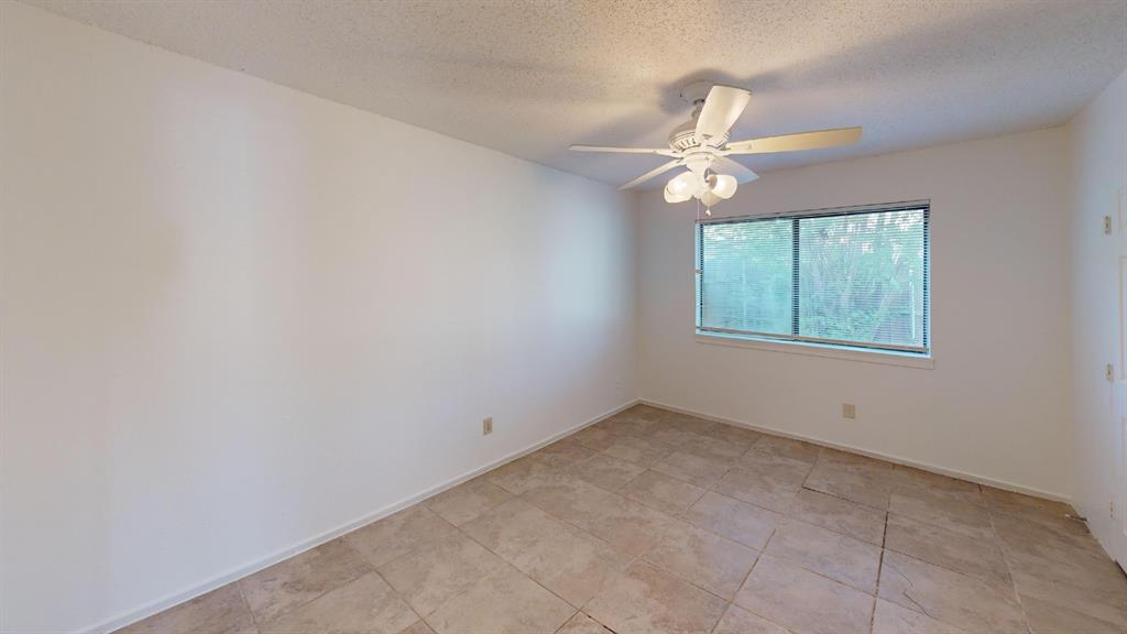 Neutral wall color, ceramic tile flooring, ceiling fan with integrated lighting, and a double-pane window