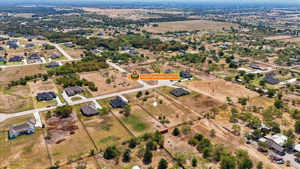 Aerial view showcasing a multi-building compound on expansive acreage with mature landscaping, open pasture land, and established tree coverage throughout the property