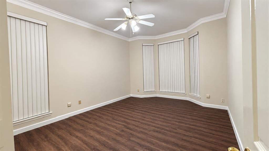 Recessed bay window, crown molding, wood-finish flooring, ceiling fan with light kit, vertical blinds