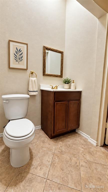 Vanity with a white countertop and gold-toned faucet, complemented by a decorative mirror