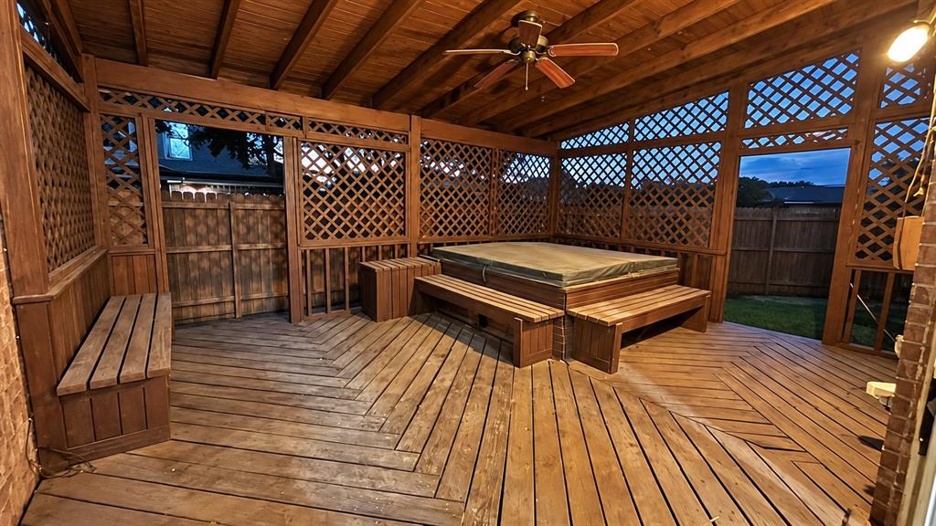 Wooden deck with geometric pattern, lattice privacy screens, built-in benches, and a ceiling fan