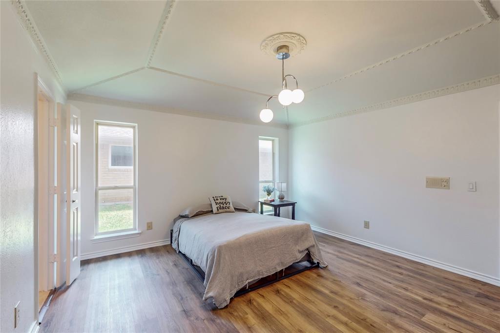 Wood-finish flooring, white walls, and a decorative ceiling medallion