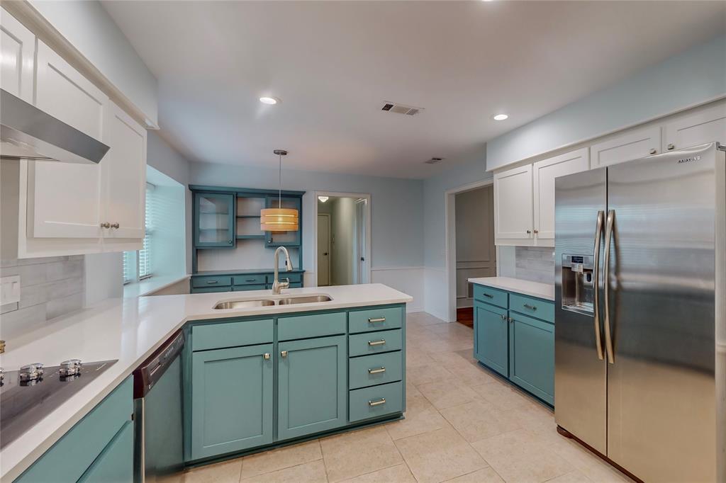Kitchen featuring white shaker upper cabinetry and teal lower cabinetry, white countertops, tile flooring, and stainless steel appliances