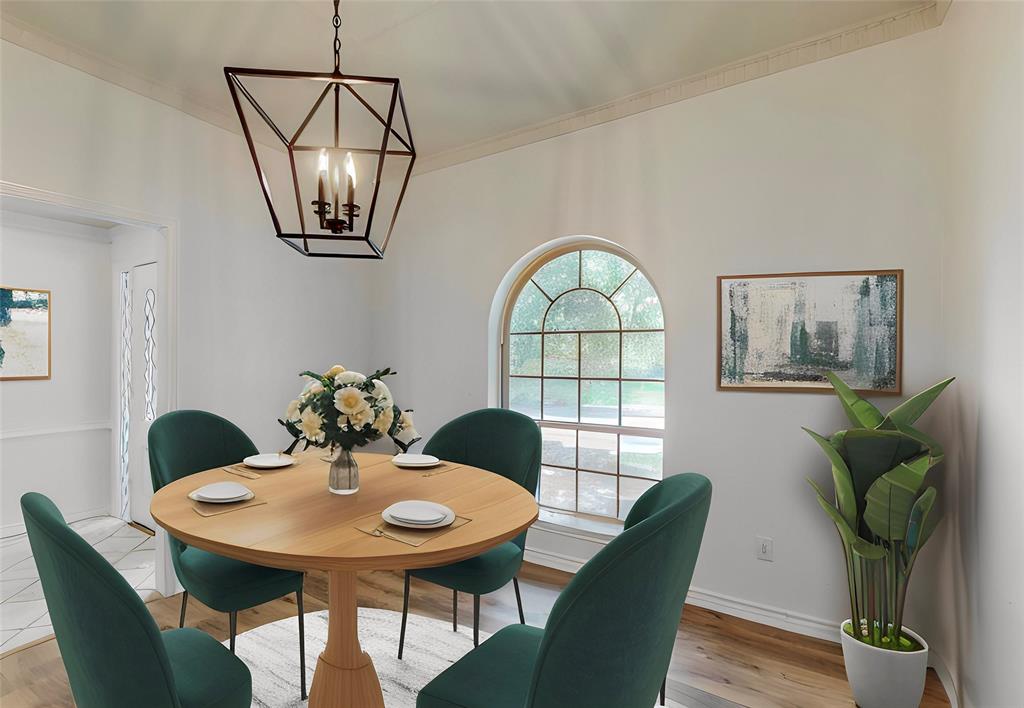 Hardwood-style flooring, arched window, crown molding, and a geometric chandelier
