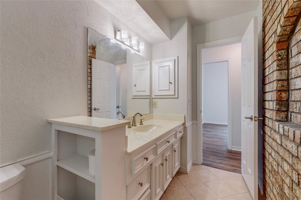 White vanity with integrated sink, polished chrome faucet, and expansive mirror