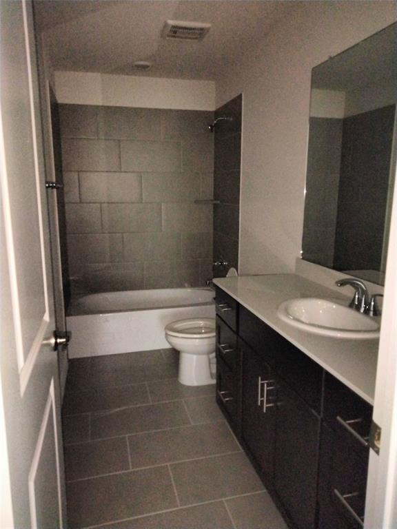 Bathroom featuring a full-size tub, subway tile shower surround, single vanity with integrated sink, and an expansive mirror
