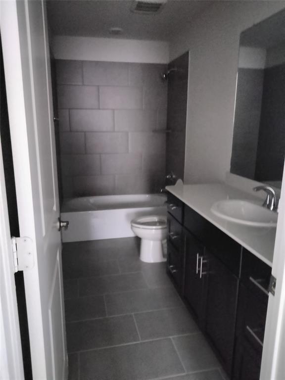Bathroom featuring a spacious vanity with white countertop, integrated sink, and dark wood-finish cabinetry