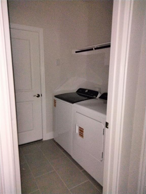 Dedicated laundry area featuring tile flooring and an integrated shelf