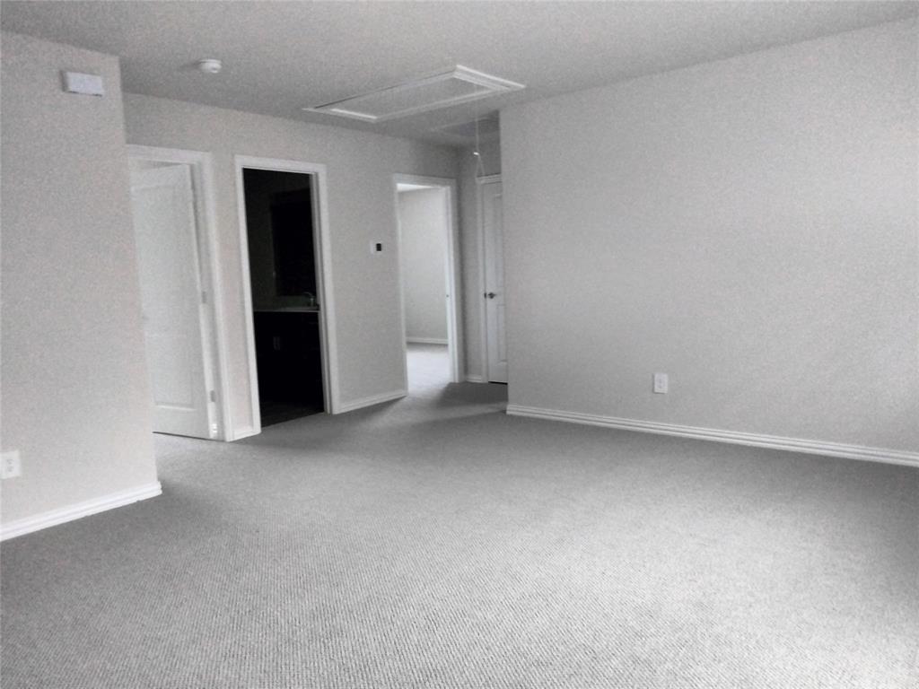 Expansive carpeted area with neutral wall finishes and multiple doorways