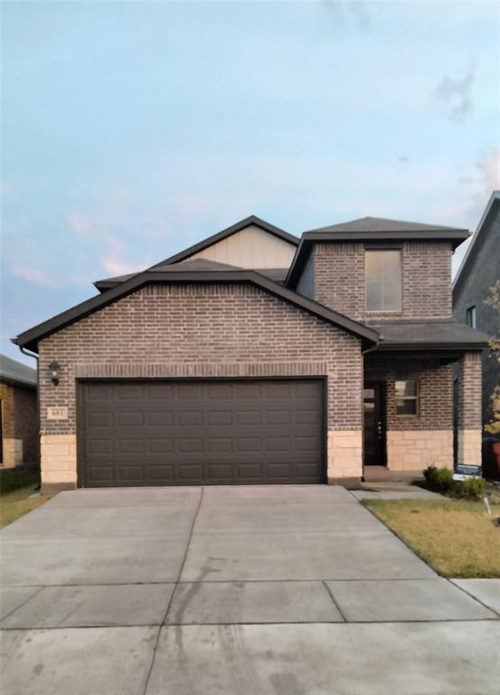 Contemporary exterior featuring dark brick, stone accents, and a dark asphalt shingle roof