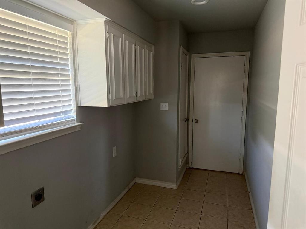 Window with horizontal blinds, overhead cabinetry, recessed lighting, and tile flooring